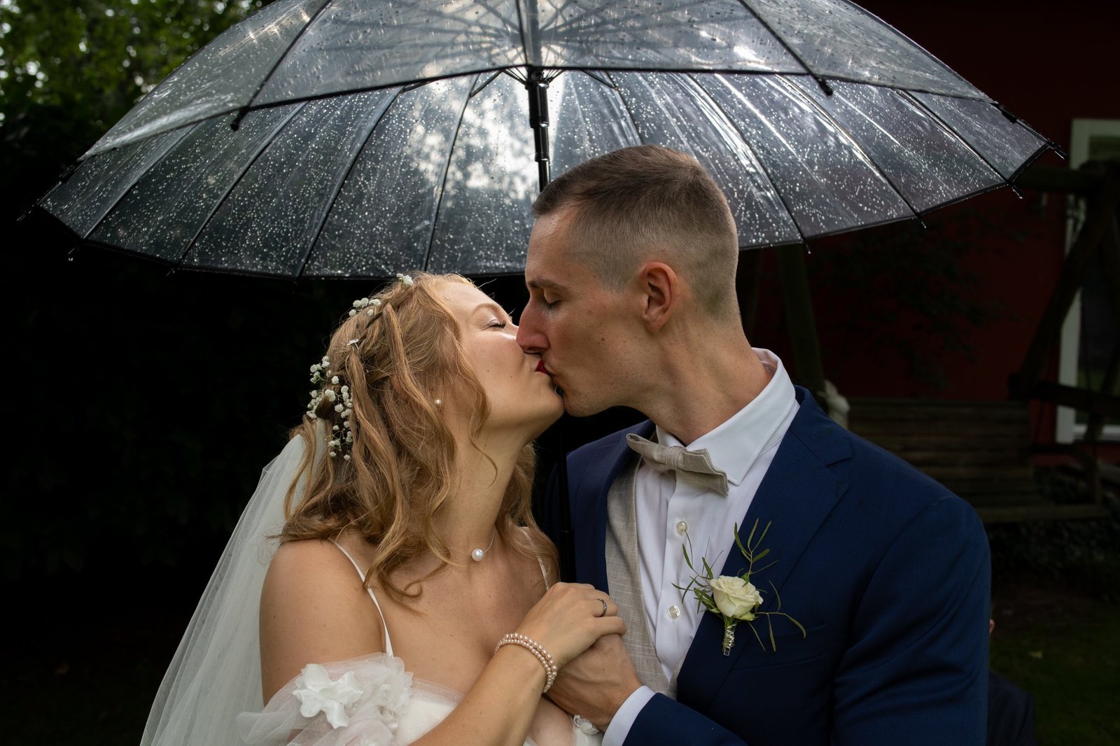 Carrie und Justin küssen sich unter dem Regenschirm
