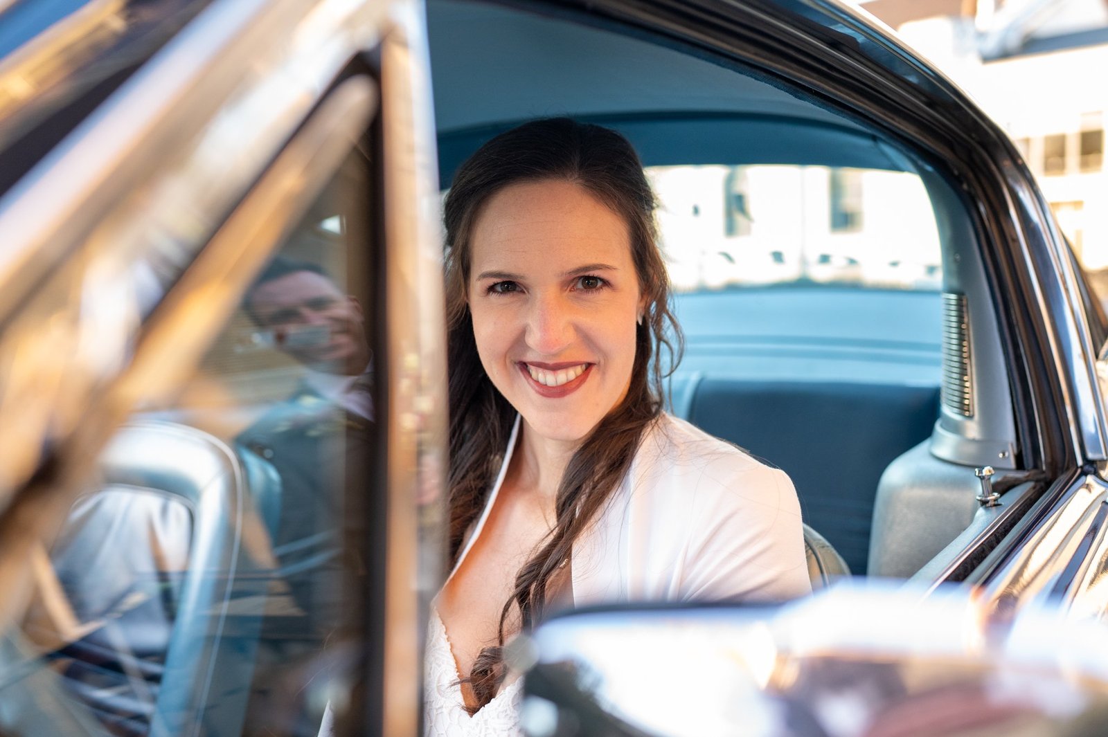 Laura lächelt aus dem geöffneten Fenster des Mustang