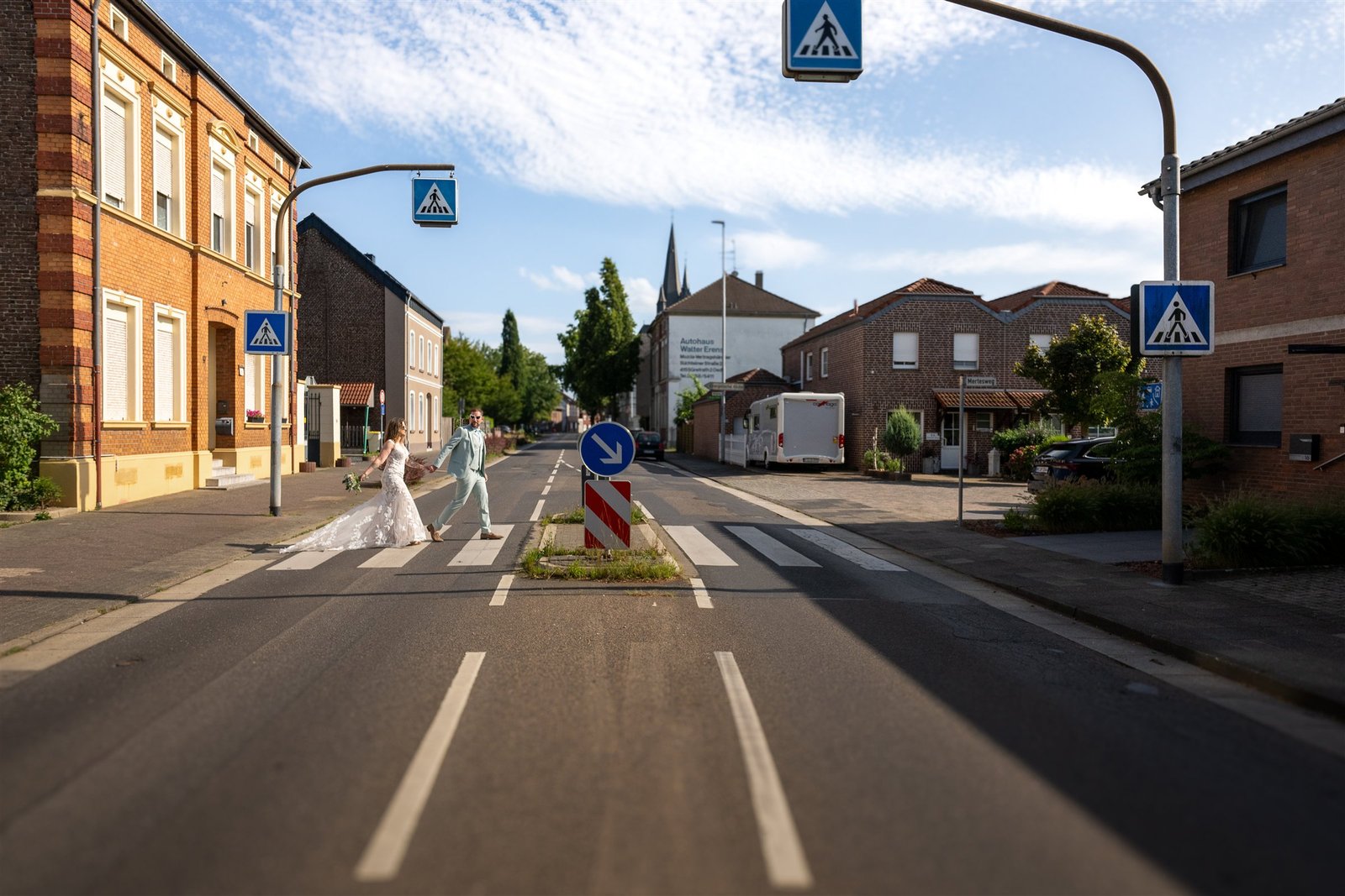 Lena und René überqueren gemeinsam eine breite Straße im Industrieviertel