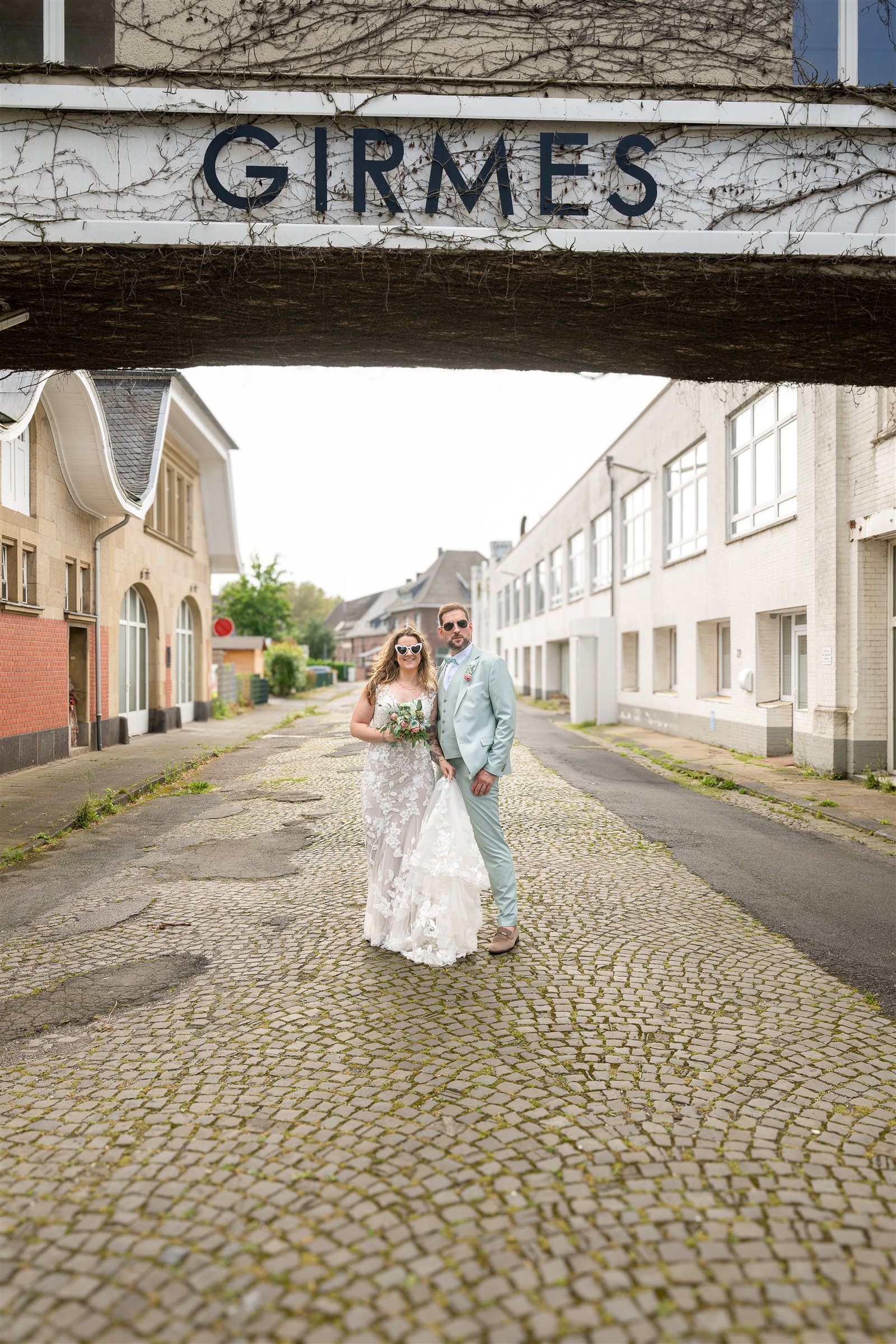 Lena und René stehen unter dem historischen Girmes-Schriftzug in einer Industriestraße