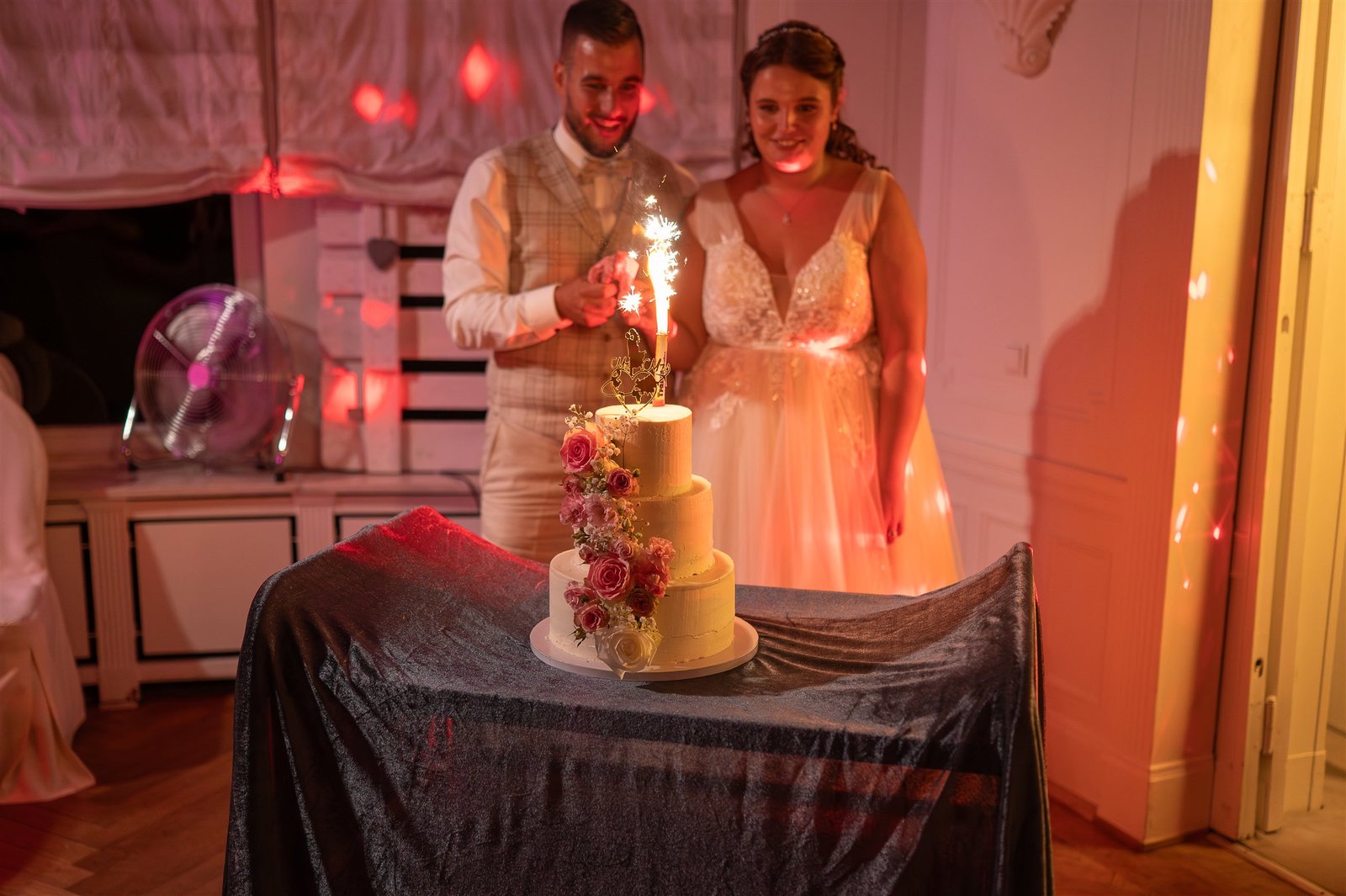 Madeleine und Pascal stehen bei Wunderkerzen hinter ihrer Hochzeitstorte