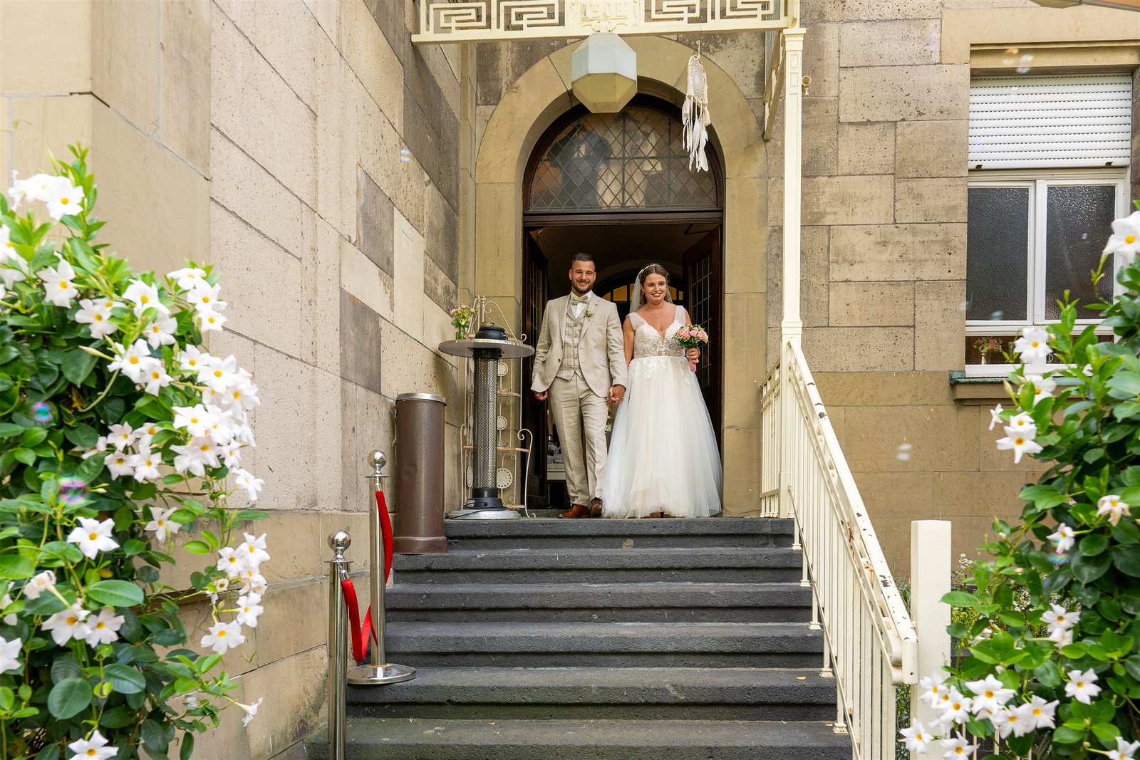 Madeleine und Pascal stehen in einer markanten architektonischen Kulisse