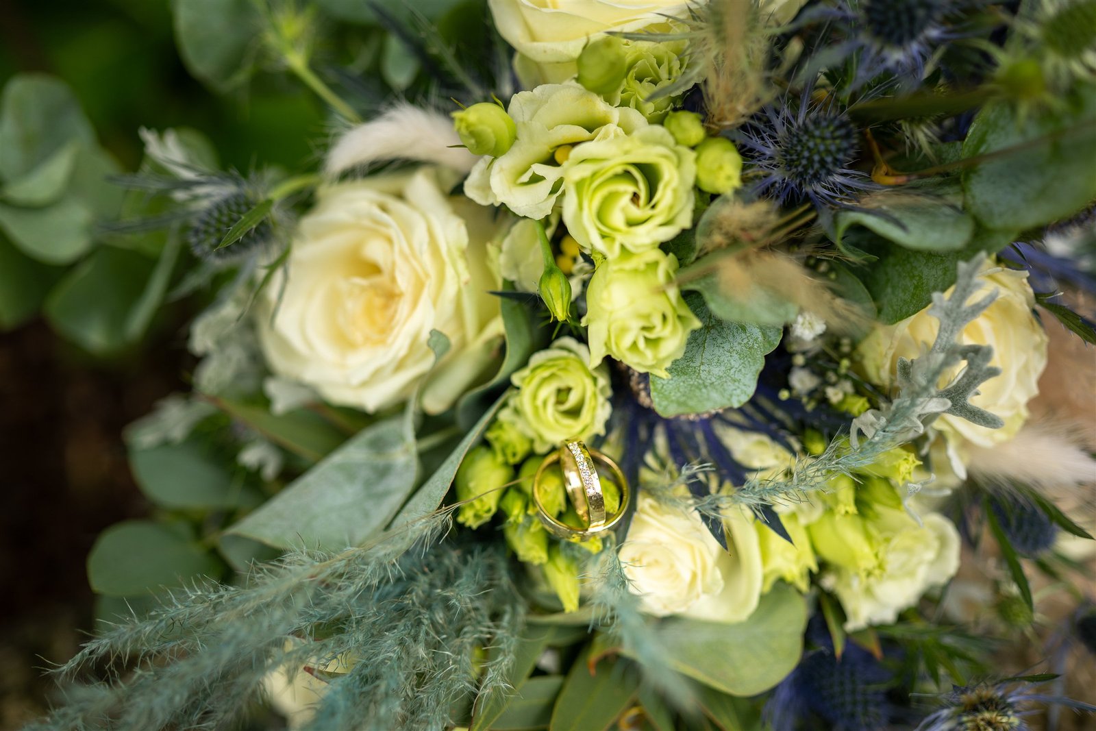 Eheringe zwischen den Blüten des Brautstraußes